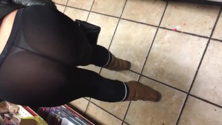 妻は店で黒いスパンデックスの公共のひもを通して見る