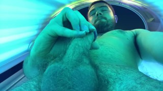 Esfregando um em uma cama de bronzeamento