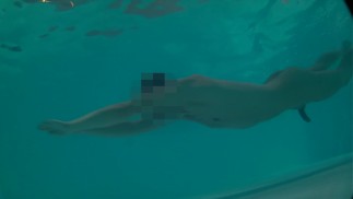 Twink perde i tronchi nella piscina dell'hotel e nuota nudo