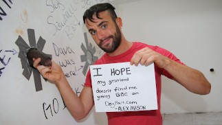 Bärtiger Kerl lutscht einen schwarzen Schwanz an einem Gloryhole