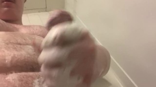Хаски парень протирает свой член в душе