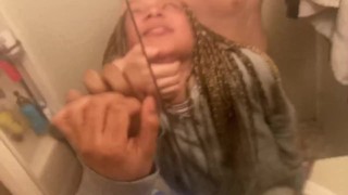 Blasian inclinado sobre el lavabo del baño mientras compañeros de cuarto en otra habitación