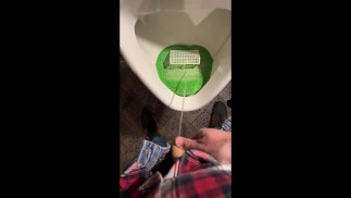 Pisser dans un urinoir dans un pub. Je joue au foot avec de l'urine