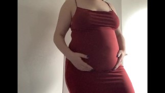 Gros ventre rond dans une robe rouge