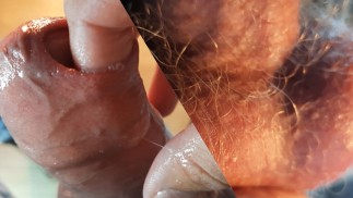Der Typ kommt reichlich, indem er seine Finger unter die Vorhaut legt