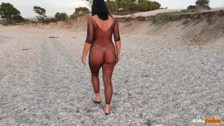 Caminando en una playa pública con traje de rejilla
