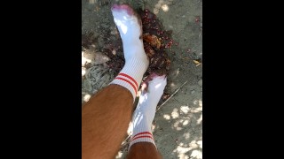 Écrasement de fruits alimentaires en plein air avec des pieds blancs chaussés