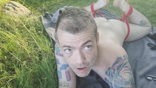 Pego nu e vulnerável por um lago público. Kayaker passando enquanto experimenta auto-escravidão