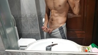 Un mec athlétique se masturbe sa grosse bite dans la salle de bain
