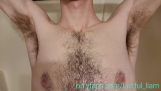 Lange jongen speelt met zijn harige oksels in de douche