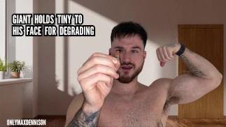 Giant holds tiny to his face for degrading