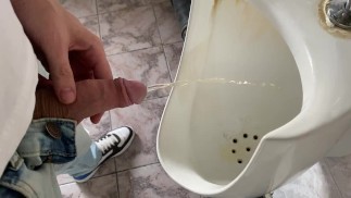 Guy orinando en el baño de la oficina pública