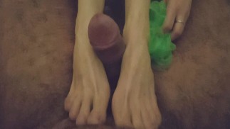 Una morena delgada hace una paja con los pies en el baño