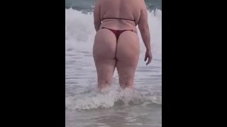 Rubia culona jugando en la playa