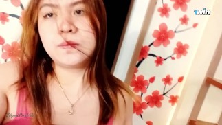 Asijská kočička utažená prstem ve videohovoru