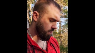 Vousatý rovný brácha trhající se svým kamarádem v lese.