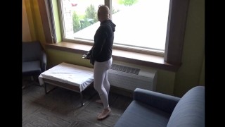 op blote voeten in leggings aftrekken in lul mouw bij het raam van het hotel