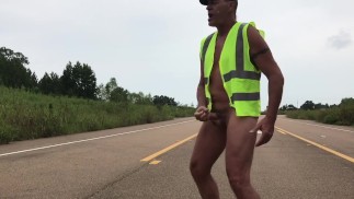 Trabajador de la construcción en medio de la carretera desnudo y cogiendose.  Come su propio semen.