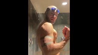 Bärtiger Schwimmer duscht in der Umkleidekabine