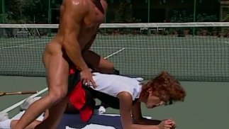 MILF rossa succhia il cazzo attraverso la rete da tennis