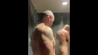 Beefy Männer duschen zusammen in der Umkleidekabine des Fitnessstudios