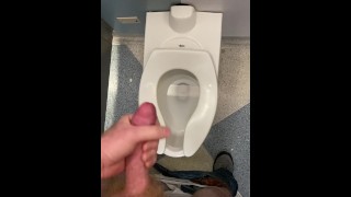 Stroking my dick in the airport bathroom with spit as lube.