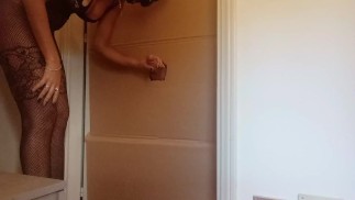 In een nylon catsuit en hoge hakken zuig ik een lul en neuk het in een gloryhole totdat het klaarkomt in mijn mond